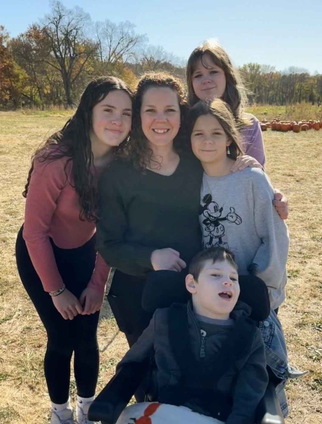 Photo of Kayla with her children, three girls and a boy